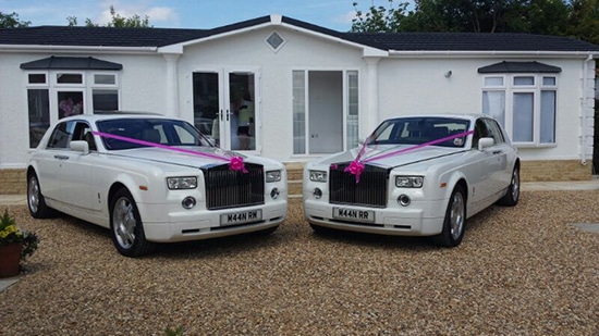 2 white rolls royce phantoms